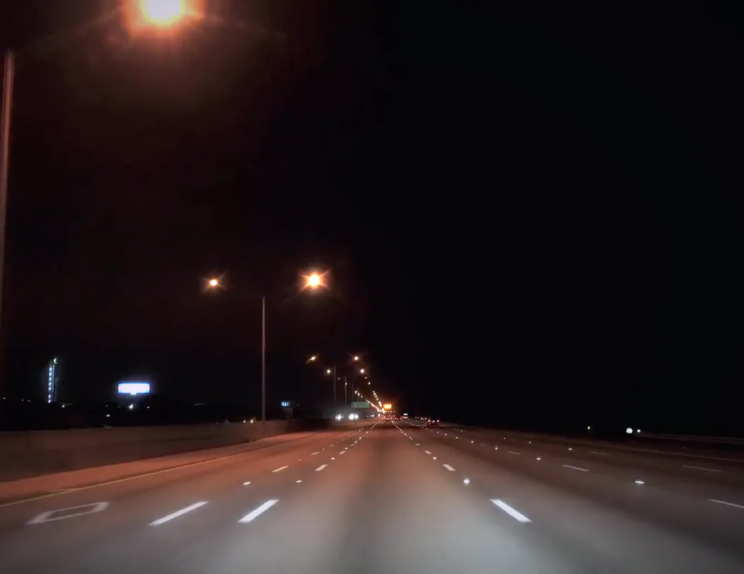 The road at night through the windshield, a highway with street lights and lane markings, under the app's recording overlay: REC, the time, 42 mph with the 45 limit sign, and the place.